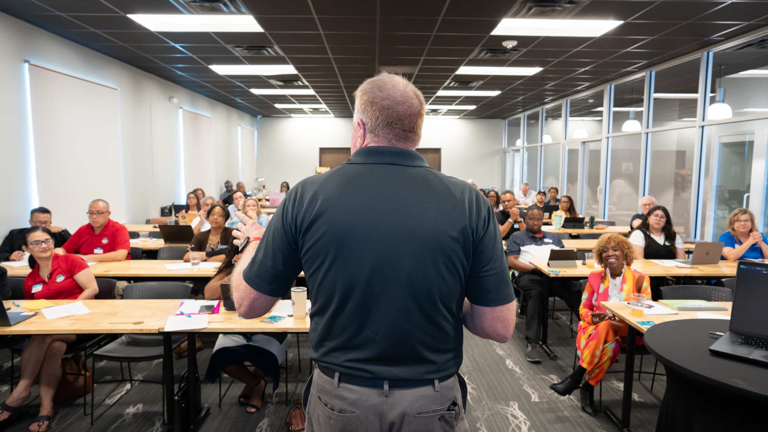 Man speaking to group from front of classroom during leadership workshop